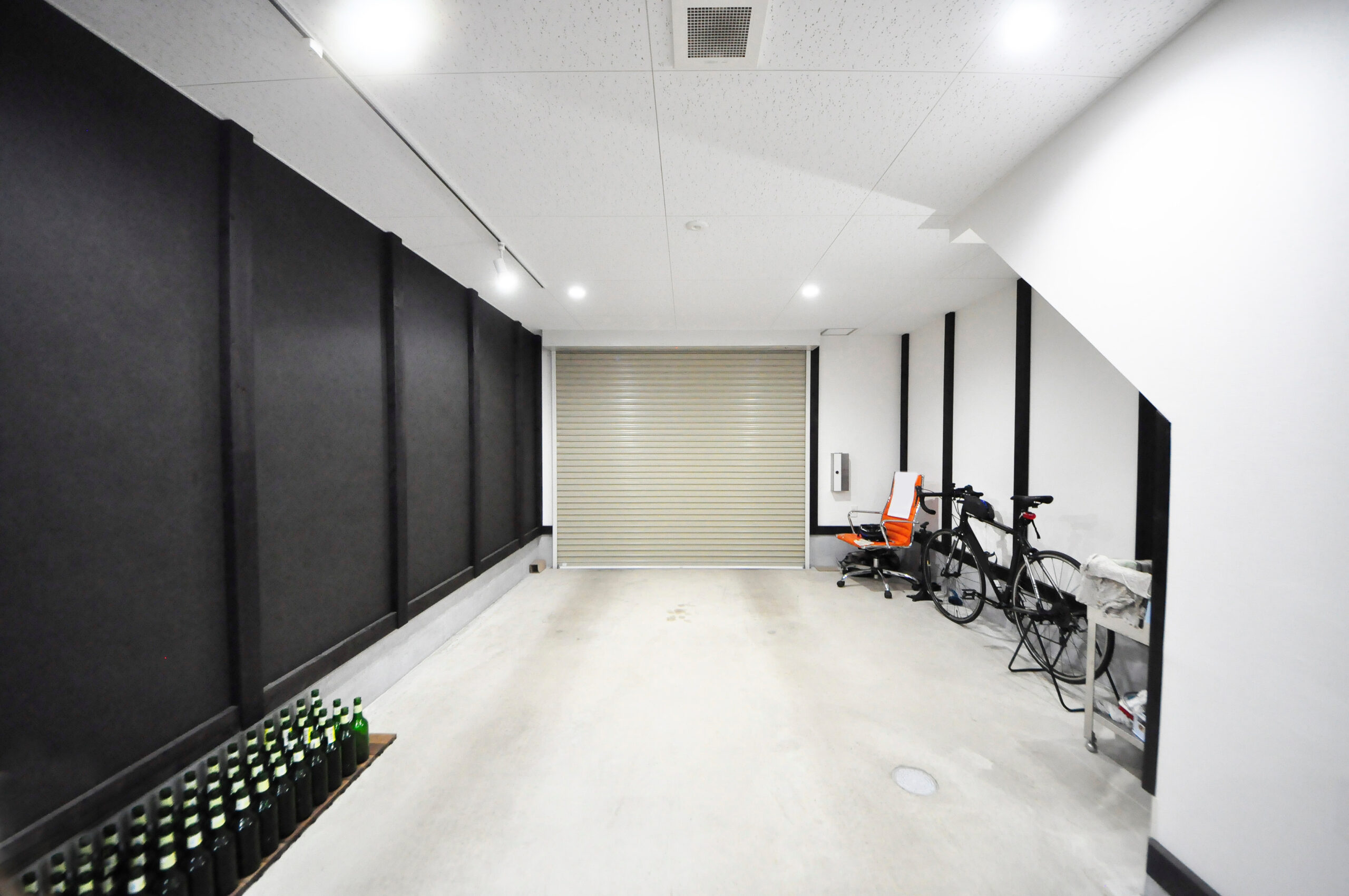 天井の高いガレージの内部と自転車を並べた土間